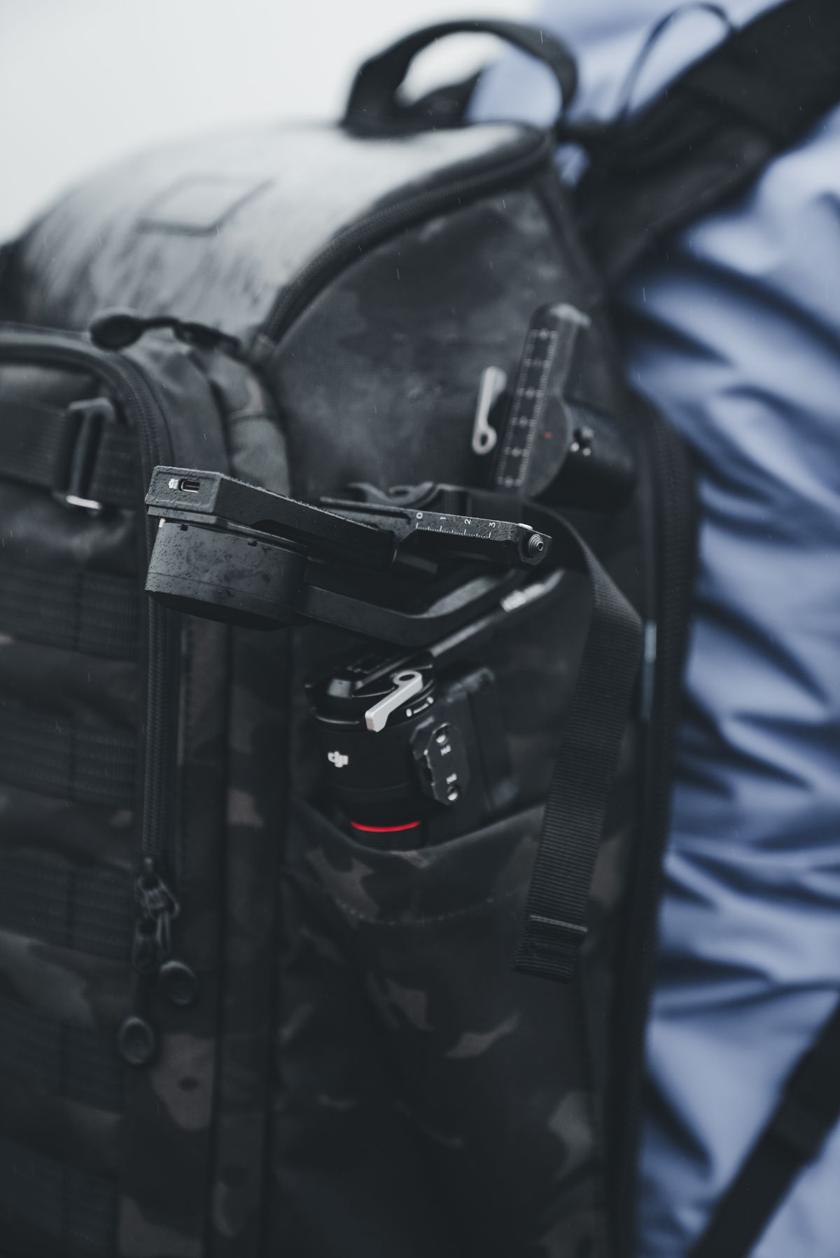 Camera equipment tucked inside the compartments of a travel bag