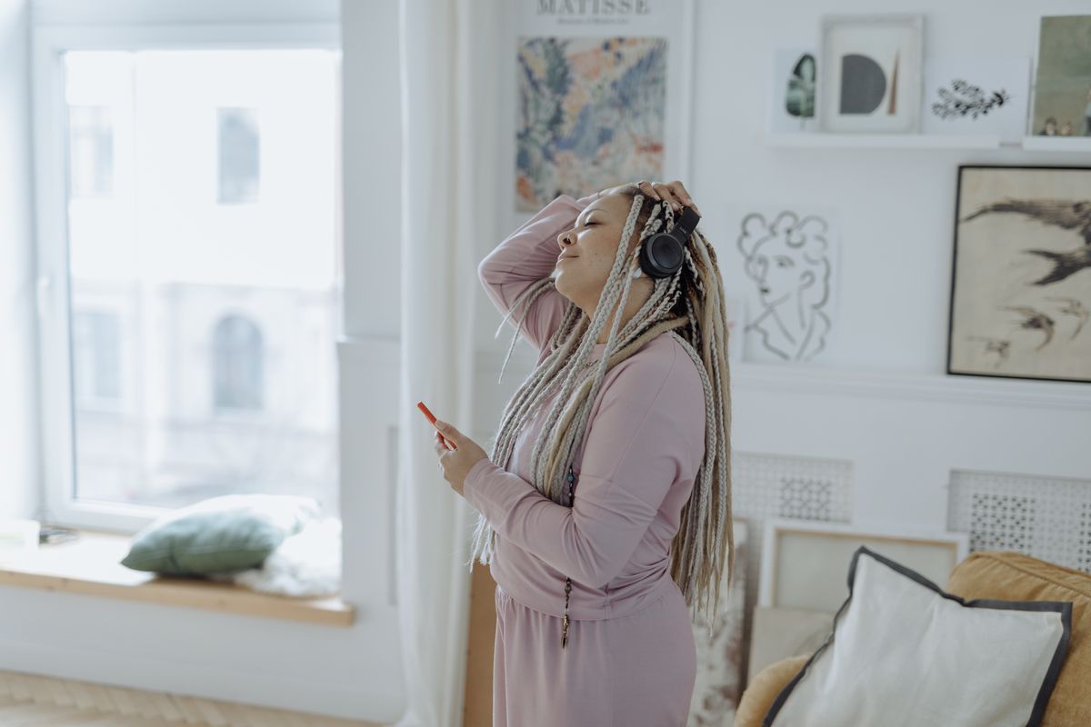 A woman listening with headphones in a living room