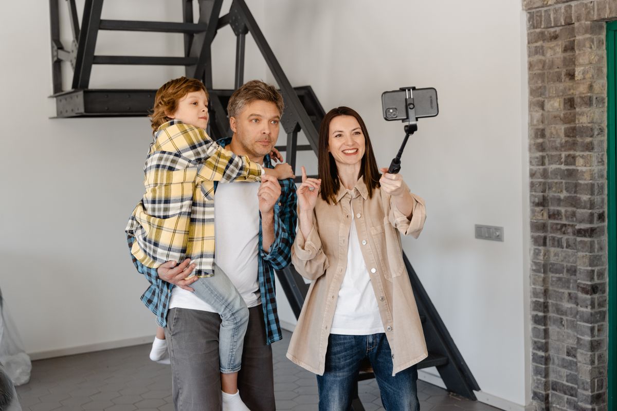 A family taking a smartphone selfie together at home